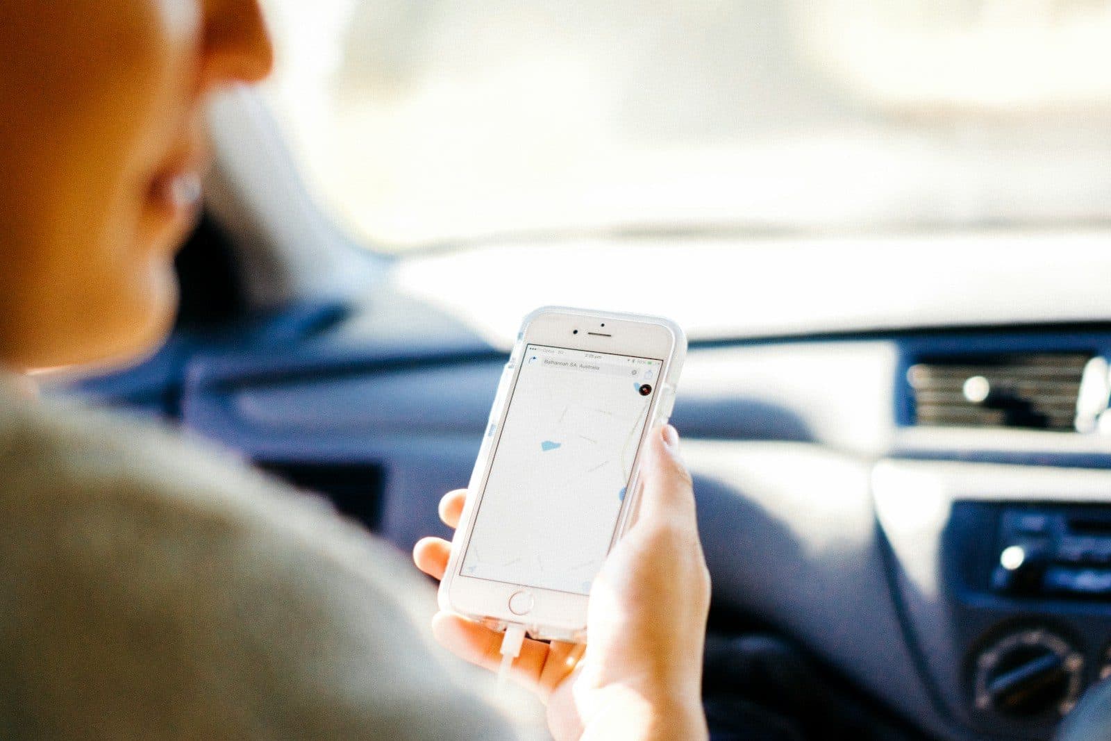 A person using a phone while sitting in a car