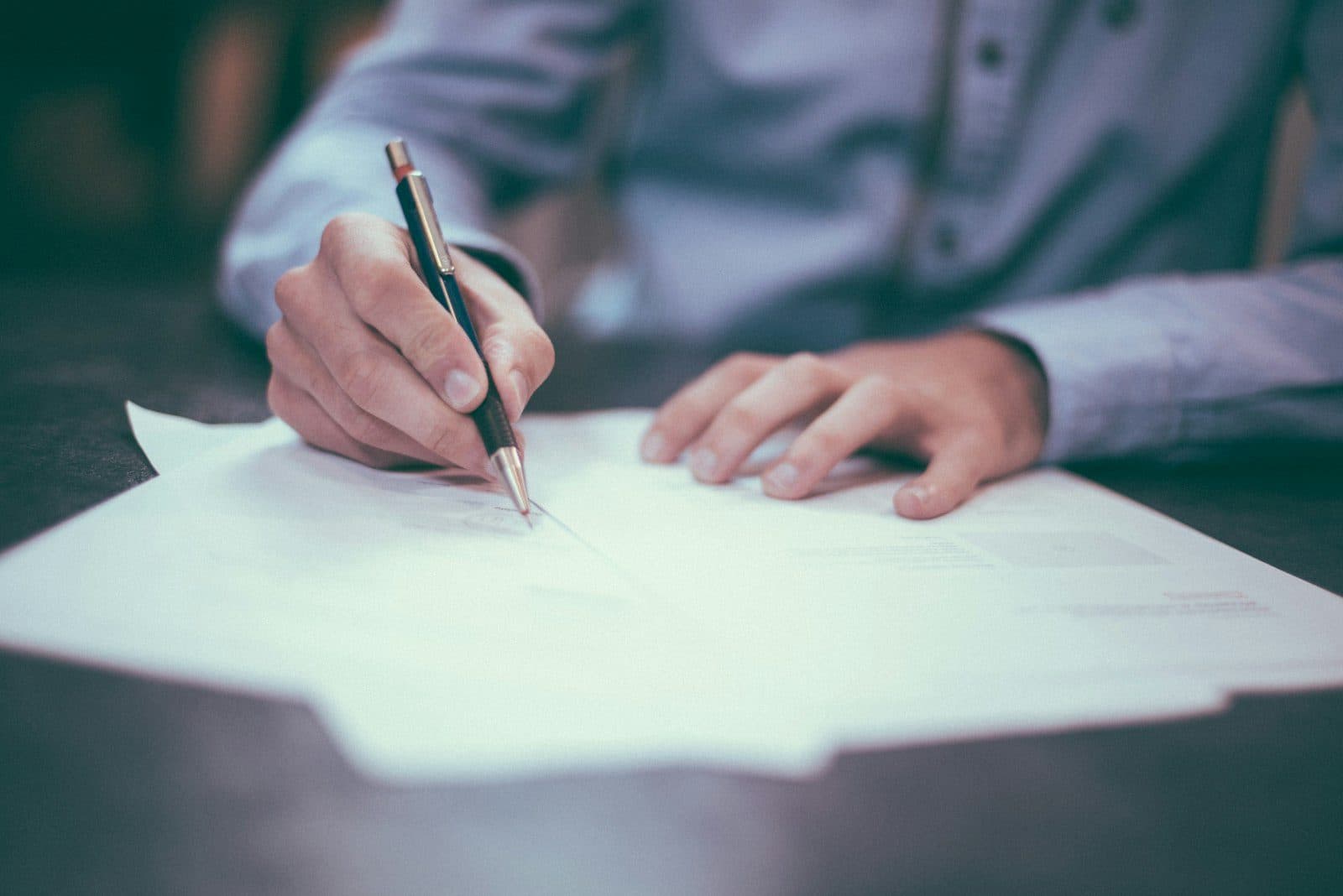 Signing a paper record at a desk